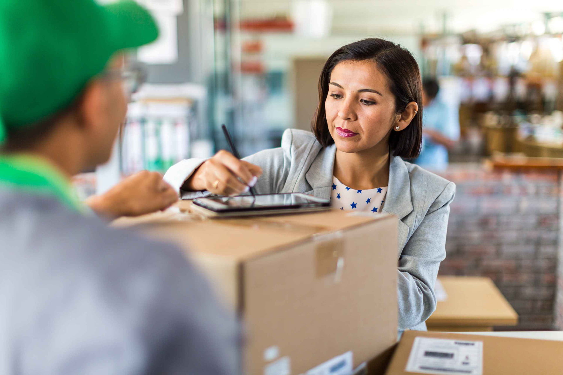 logística para e-commerce - mulher recebeendo caixa de um entregador