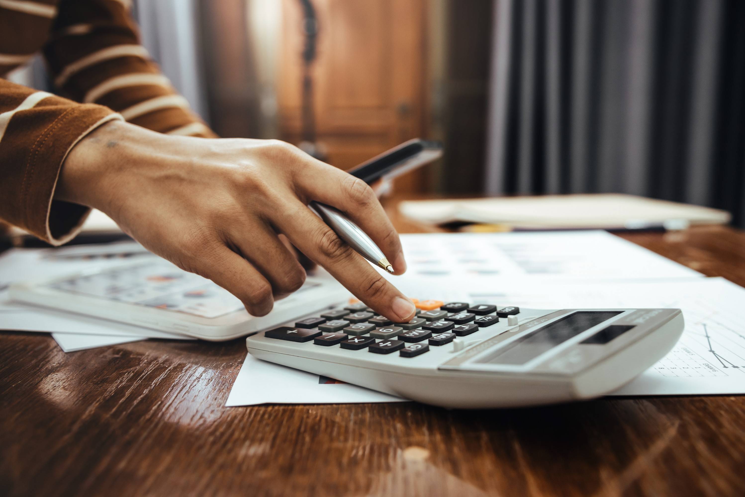elisão fiscal - pessoa utilizando calculadora para pagar impostos corretamente