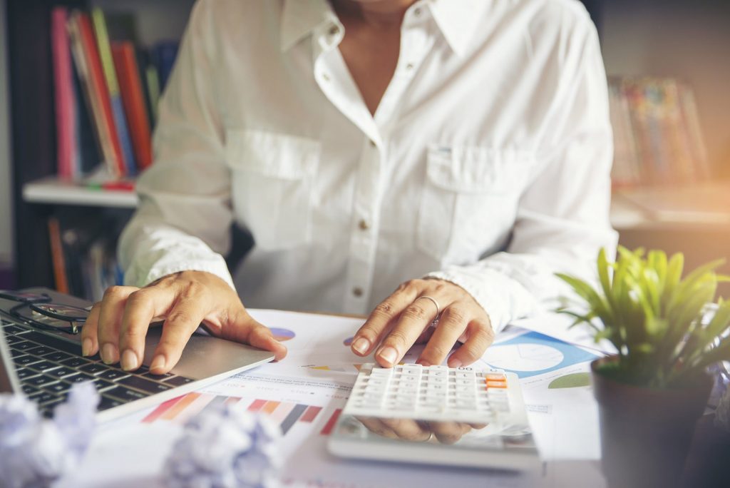 gestão de custos - pessoa fazendo cálculos em uma mesa de escritório