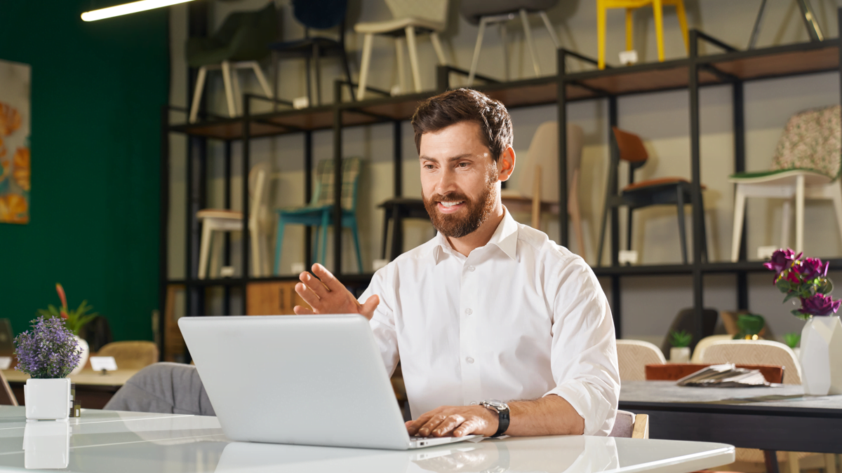gerenciar uma loja de móveis - homem acessando sistema de gestão no notebook em uma loja de móveis